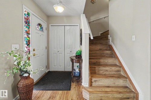 Entryway featuring wood-finish flooring, a white front door with decorative glass panels, and a coordinating sidelight - 11633 167B Avenue, Edmonton, AB - Indoor Photo Showing Other Room