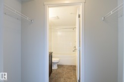 Bathroom entrance with wire shelving and a white tub-shower combination featuring subway tiling - 