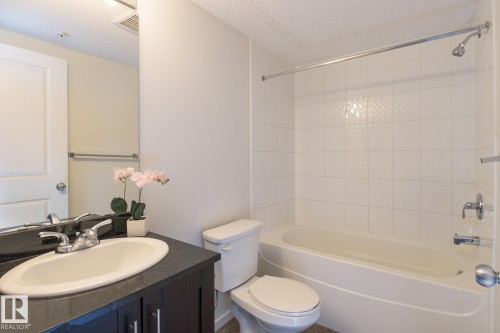 Bathroom featuring a dark wood-finish vanity with a white oval sink and chrome faucet - 111 25 Element Dr, St. Albert, AB - Indoor Photo Showing Bathroom