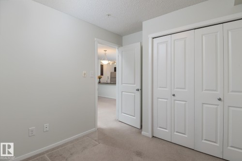 White bi-fold closet doors with brushed nickel hardware - 111 25 Element Dr, St. Albert, AB - Indoor Photo Showing Other Room