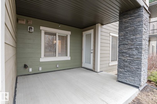 Covered concrete patio with a stone-clad pillar - 111 25 Element Dr, St. Albert, AB - Outdoor With Exterior