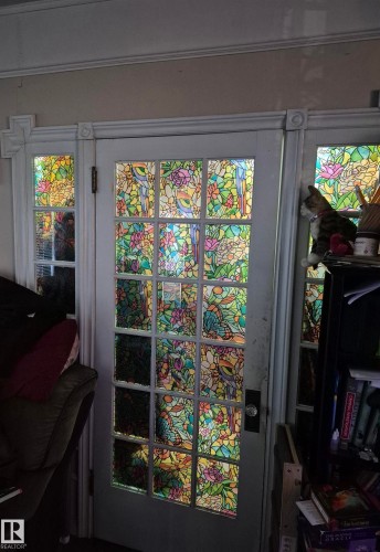 Panel door with colorful patterned glass inserts, flanked by matching sidelights - 11301 87 Street, Edmonton, AB - Indoor Photo Showing Other Room