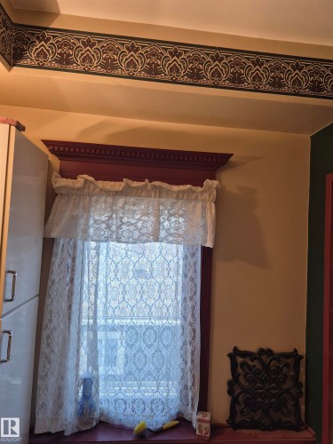 Window with decorative red trim and white lace curtains - 11301 87 Street, Edmonton, AB - Indoor Photo Showing Other Room