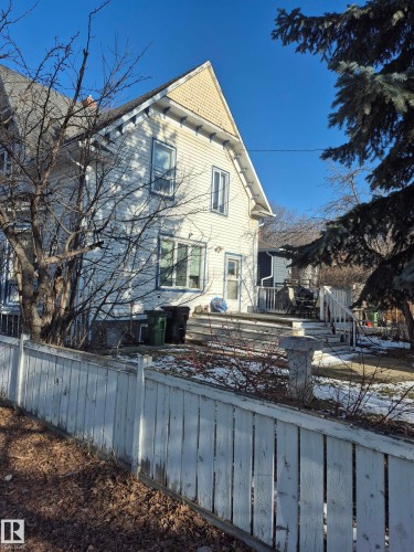 Two-story property featuring white siding and a gable roof with yellow shingle detailing and back deck (3.50x3.50) - 11301 87 Street, Edmonton, AB - Outdoor