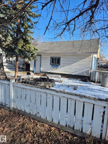 Detached double car garage featuring horizontal siding, a gabled roof, and a single window with decorative trim - 11301 87 Street, Edmonton, AB - Outdoor
