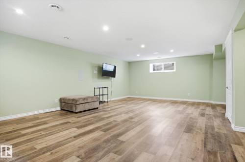 Spacious room featuring wood-finish flooring, recessed lighting, a white trim package, and a window with white casing - 28 Hewitt Circle, Spruce Grove, AB - Indoor