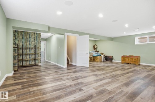Spacious room with wood-finish flooring, recessed lighting, and pale green wall paint - 28 Hewitt Circle, Spruce Grove, AB - Indoor