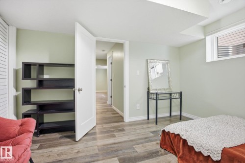 Light green walls complement wood-finish flooring throughout this interior space - 28 Hewitt Circle, Spruce Grove, AB - Indoor Photo Showing Bedroom