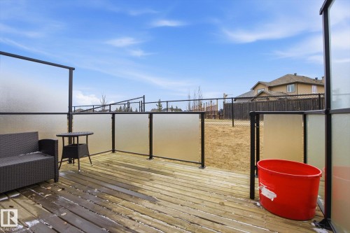 Wood-finish deck with a glass panel railing system, offering an outdoor extension to the property - 28 Hewitt Circle, Spruce Grove, AB - Outdoor With Exterior