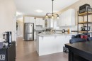 Kitchen featuring white cabinetry, stainless steel appliances, a center island with a light-colored countertop, and a tiled backsplash - 28 Hewitt Circle, Spruce Grove, AB  - Indoor Photo Showing Kitchen With Stainless Steel Kitchen With Upgraded Kitchen 