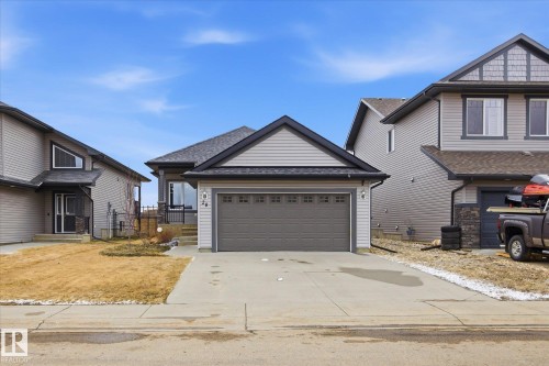 Single-story residence featuring light gray siding with dark trim, an attached two-car garage, and a concrete driveway - 28 Hewitt Circle, Spruce Grove, AB - Outdoor