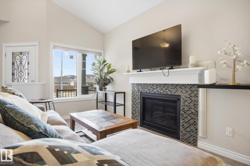 Living area featuring a floor-to-ceiling fireplace with mosaic tile surround and a classic white mantel - 28 Hewitt Circle, Spruce Grove, AB - Indoor Photo Showing Living Room With Fireplace