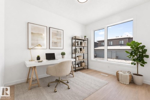 Bright and versatile room featuring light wood flooring, a large window, and a built-in shelving unit - 94 Blackbird Bend, Fort Saskatchewan, AB - Indoor Photo Showing Office