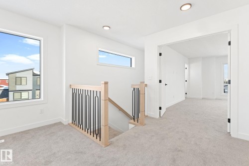 The property features light-colored carpeting, white walls, and recessed lighting - 94 Blackbird Bend, Fort Saskatchewan, AB - Indoor Photo Showing Other Room
