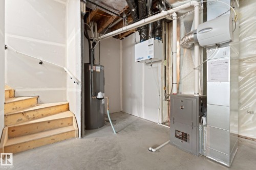Utility room featuring a water heater, furnace, and exposed ductwork - 94 Blackbird Bend, Fort Saskatchewan, AB - Indoor Photo Showing Basement