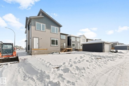 The property features a two-story exterior with light gray siding and dark gray vertical accents - 94 Blackbird Bend, Fort Saskatchewan, AB - Outdoor