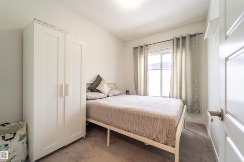 Room with light gray carpet flooring and white walls - 117 804 Welsh Drive, Edmonton, AB - Indoor Photo Showing Bedroom