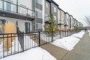 Modern townhome exterior featuring contemporary architectural design elements, a private balcony with glass railing, and a dark-paneled main entry door - 117 804 Welsh Drive, Edmonton, AB  - Outdoor With Balcony 