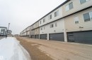 Contemporary townhome residences featuring multi-tone siding and modern garage doors with frosted glass panels - 117 804 Welsh Drive, Edmonton, AB  - Outdoor With Exterior 