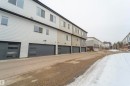 Modern multi-level townhome featuring a neutral exterior siding and attached garage with frosted-panel windows - 117 804 Welsh Drive, Edmonton, AB  - Outdoor With Exterior 