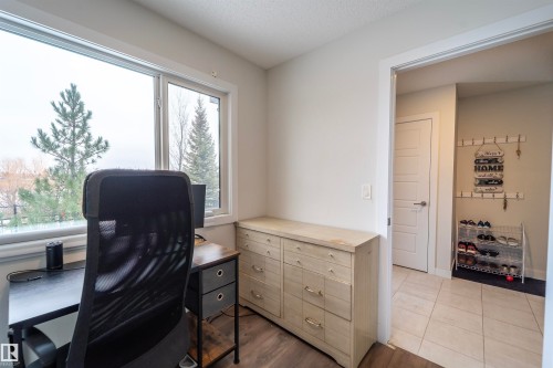 Bright room featuring a large window, light-toned walls, and wood-finish flooring - 117 804 Welsh Drive, Edmonton, AB - Indoor Photo Showing Office
