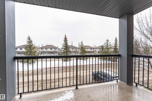 Private balcony featuring a black metal railing and a textured overhead finish - 219 646 Mcallister Loop, Edmonton, AB - Outdoor With Balcony With Exterior