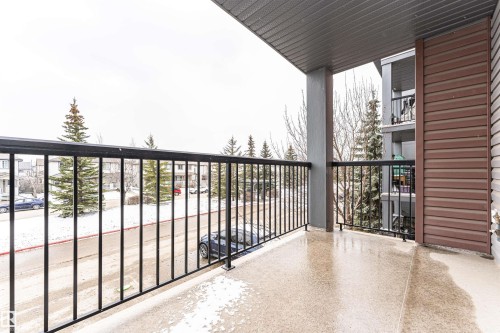 Outdoor balcony featuring a textured concrete floor, black metal railing, and a gray soffit - 219 646 Mcallister Loop, Edmonton, AB - Outdoor With Balcony With Exterior