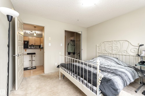 Bedroom featuring carpeting, light neutral wall color, and a ceiling-mounted light fixture - 219 646 Mcallister Loop, Edmonton, AB - Indoor Photo Showing Bedroom