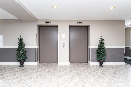 Two elevators with neutral-toned doors and brushed metal accents - 219 646 Mcallister Loop, Edmonton, AB - Indoor Photo Showing Other Room