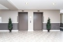 Two elevators with neutral-toned doors and brushed metal accents - 219 646 Mcallister Loop, Edmonton, AB  - Indoor Photo Showing Other Room 
