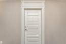 Crisp white six-panel door with decorative trim and brushed nickel hardware - 219 646 Mcallister Loop, Edmonton, AB  -  Photo Showing Other Room 