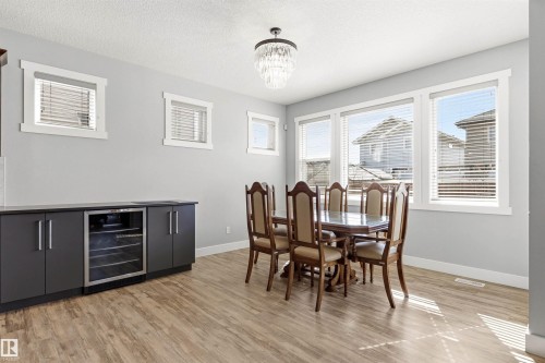 Open-concept space featuring wood-finish flooring, light gray wall paint, and multiple windows with white trim - 9812 224 Street, Edmonton, AB - Indoor Photo Showing Dining Room