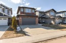 Two-story residence featuring a dark paneled garage door, brick facade accents, and horizontal siding - 9812 224 Street, Edmonton, AB  - Outdoor With Facade 