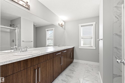Bathroom featuring a dual vanity with a white countertop and wood-finish cabinetry - 9812 224 Street, Edmonton, AB - Indoor Photo Showing Bathroom