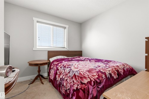 Bedroom featuring light gray walls, carpeted flooring, and a white-trimmed window with blinds - 9812 224 Street, Edmonton, AB - Indoor Photo Showing Bedroom