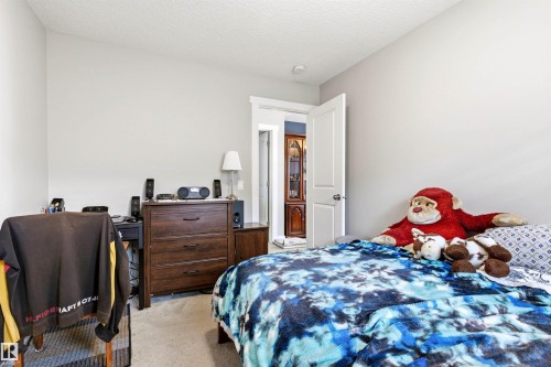 Carpeted room with light gray walls, white trim, and a textured ceiling - 9812 224 Street, Edmonton, AB - Indoor Photo Showing Bedroom