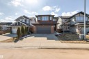 Contemporary home exterior featuring a brick facade, dark wood-tone siding, and a dark garage door - 9812 224 Street, Edmonton, AB  - Outdoor With Facade 