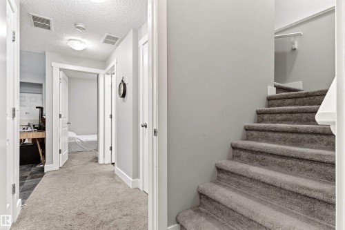 Plush carpeted staircase with white handrail and light gray wall paint - 9812 224 Street, Edmonton, AB - Indoor Photo Showing Other Room