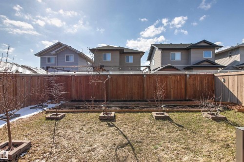 Expansive backyard featuring a wood fence, mature trees, and a garden bed - 9812 224 Street, Edmonton, AB - Outdoor