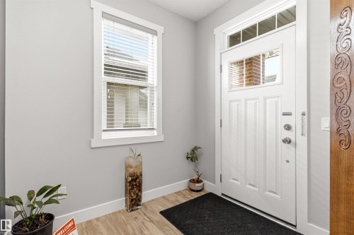 Entryway featuring a white paneled door with integrated glass, transom window, and a sidelight with carved wood detailing - 9812 224 Street, Edmonton, AB - Indoor Photo Showing Other Room