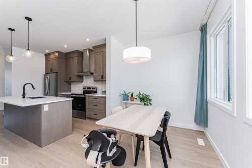Open-concept kitchen and dining area featuring light wood-finish flooring - 3367 Erlanger Bend, Edmonton, AB - Indoor