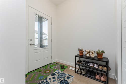 Entryway featuring a partially glass-paned white door and light wood-finish flooring - 3367 Erlanger Bend, Edmonton, AB - Indoor Photo Showing Other Room