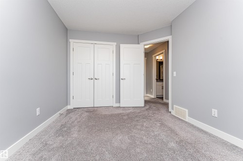 Bedroom featuring light grey walls, white trim, and grey carpet flooring - 16420 15 Avenue, Edmonton, AB - Indoor Photo Showing Other Room