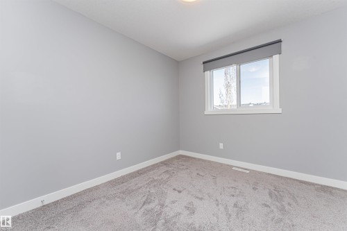 Room featuring light gray painted walls, a single window with white trim, and a neutral-toned carpet - 16420 15 Avenue, Edmonton, AB - Indoor Photo Showing Other Room