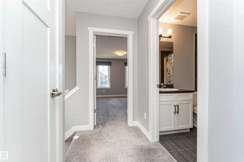 Upper-level hallway featuring light gray walls, white trim, and gray carpeted flooring - 16420 15 Avenue, Edmonton, AB - Indoor Photo Showing Other Room