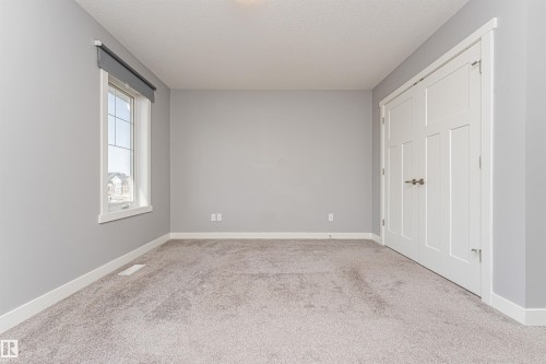 Spacious interior room featuring light gray walls and plush carpet flooring - 16420 15 Avenue, Edmonton, AB - Indoor Photo Showing Other Room