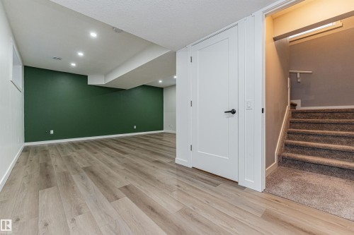 Finished basement space featuring wood-finish flooring and recessed lighting - 16420 15 Avenue, Edmonton, AB - Indoor Photo Showing Other Room