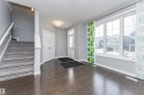 Entryway featuring rich wood-finish flooring, a multi-pane glass door, and a carpeted staircase with a white railing - 16420 15 Avenue, Edmonton, AB  - Indoor Photo Showing Other Room 