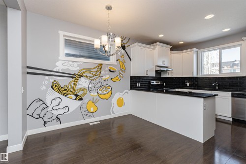Modern kitchen and dining area featuring dark wood-finish flooring - 16420 15 Avenue, Edmonton, AB - Indoor Photo Showing Kitchen