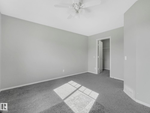 This room features light gray walls, gray carpeting, and a ceiling fan - 175 150 Edwards Drive, Edmonton, AB - Indoor Photo Showing Other Room